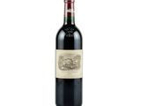 a close up of a bottle of red wine on a white surface