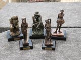 quatre figurines en bronze représentant une femme, un homme et un chat