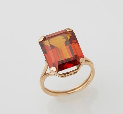 a close up of a ring with a red stone in it