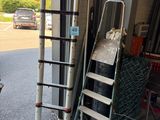 une échelle appuyée contre le mur, à côté d'un tas de bois