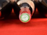 several bottles of wine are lined up on a red surface