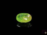 a close up of a green jade stone on a black surface
