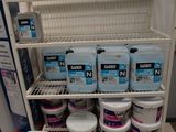 plusieurs bidons de produits d'entretien sur une étagère dans un magasin
