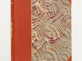 a book with a red cover sitting on top of a white table