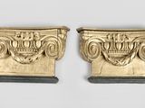 une paire de cornes sculptées, ornées d'une couronne de chaque côté