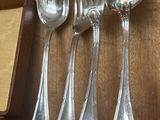 cinq cuillères en argent et deux cuillères en argent sur une table