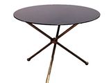 une table ronde en verre avec des pieds dorés et un plateau noir