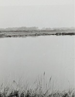 une photo en noir et blanc d'un lac avec un bateau dessus