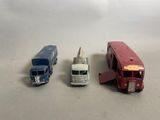 trois camions miniatures posés les uns à côté des autres sur une table