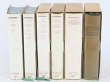 plusieurs livres sont alignés sur une surface blanche