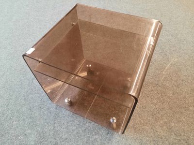 une boîte en plastique transparent posée par terre, par terre