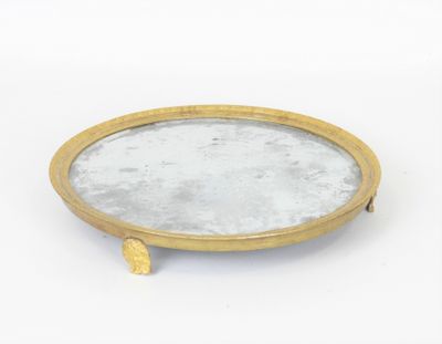 plateau en laiton orné d'un miroir, posé sur une surface blanche