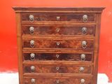an old wooden chest of drawers against a red wall