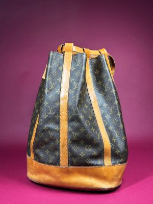 a louis vuitton handbag on a pink background