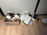 a box full of items on the floor next to a wall