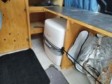 a white toilet sitting inside of a wooden cabinet