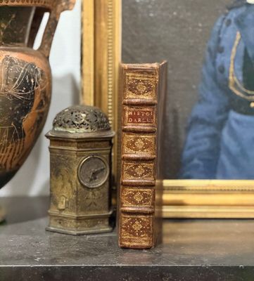 une photo d'une photo représentant une femme et une horloge posées sur une étagère