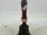 a black and gold bell with a tag on it