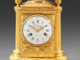 une horloge en or surmontée d'un oiseau