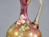vase en verre violet et doré, orné de fleurs sur un fond gris