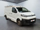 the white van is parked in a large room with a black floor
