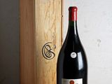 une bouteille de vin posée sur une table à côté d'une caisse en bois