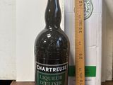 Des bouteilles d'alcool sont posées sur une table en bois à côté d'une règle.