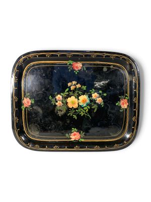 un plateau noir orné de fleurs jaunes et roses