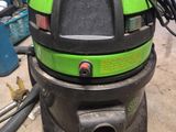 une photo d'un aspirateur vert et noir posé sur une table