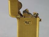 a gold lighter that is sitting on a white surface