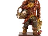 une figurine représentant un homme tenant un panier rempli de nourriture