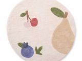 une photo d'un tapis rond orné de fruits et de baies