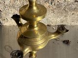 une petite théière en laiton posée sur une table