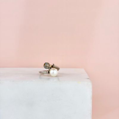 une bague en perle posée sur un bloc blanc