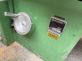 a close up of a green machine with a button on it ' s side