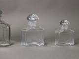 three small glass bottles sitting next to each other on top of a table