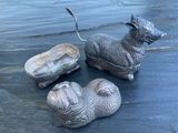 trois statues d'animaux posées les unes à côté des autres sur une table