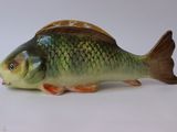 a small fish figurine sitting on a white surface