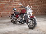 a red motorcycle parked in front of a brick wall