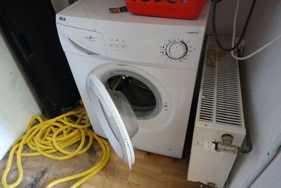 une machine à laver blanche surmontée d'un panier rouge
