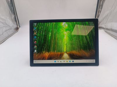 un ordinateur portable ouvert posé sur une table blanche