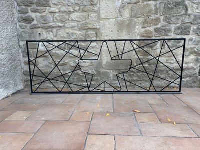a black iron fence with a geometric design on it