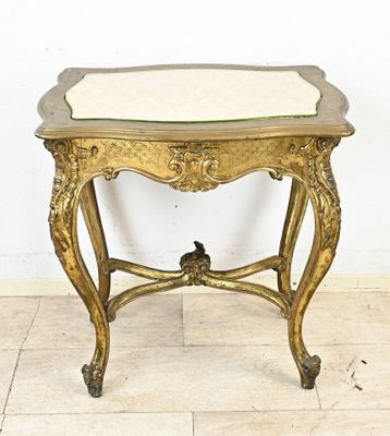 une petite table avec un plateau en marbre sur un sol carrelé