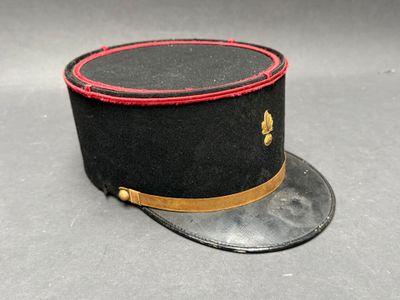 un chapeau noir orné d'un ruban rouge sur le dessus