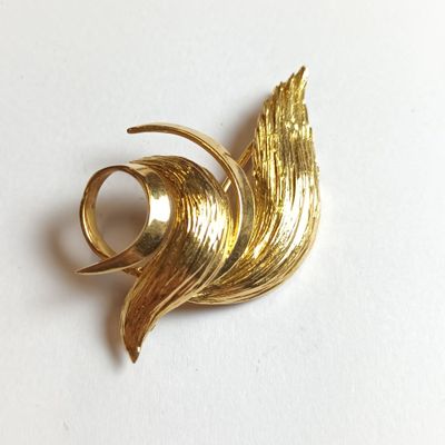 une broche en or ornée d'un motif incurvé