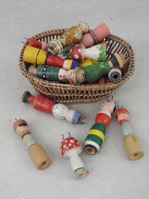 un panier rempli de petites perles en bois et de bobines en bois