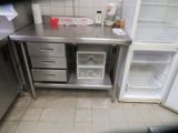 a small kitchen with a stainless steel counter and a refrigerator