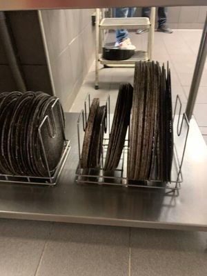 de nombreuses assiettes et casseroles empilées sur une étagère dans la cuisine