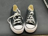 black and white converses with white laces are on a black surface