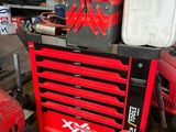 une boîte à outils rouge posée sur une pile d'outils